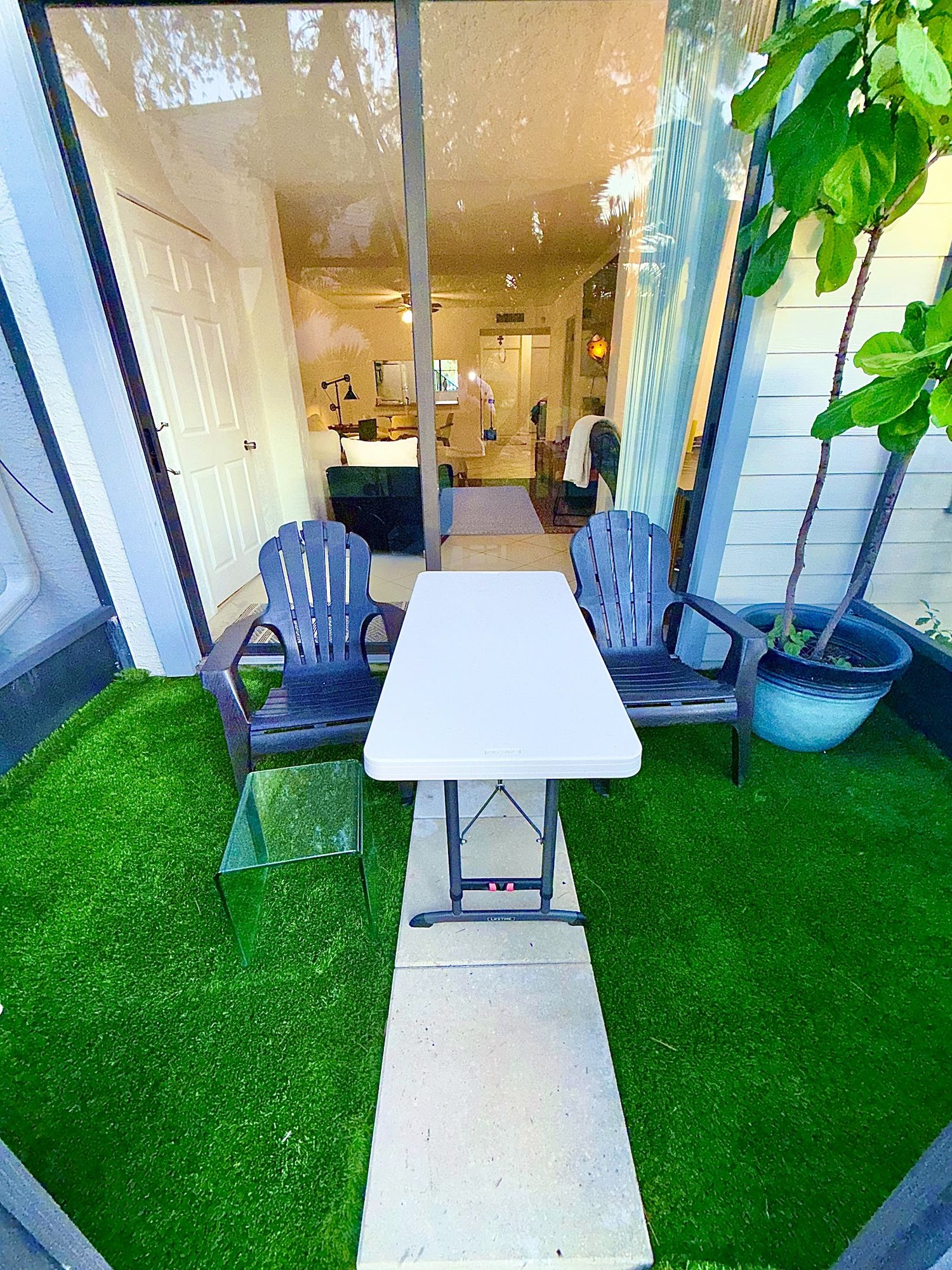 Private screened lanai with turf, Adirondack chairs and patio table